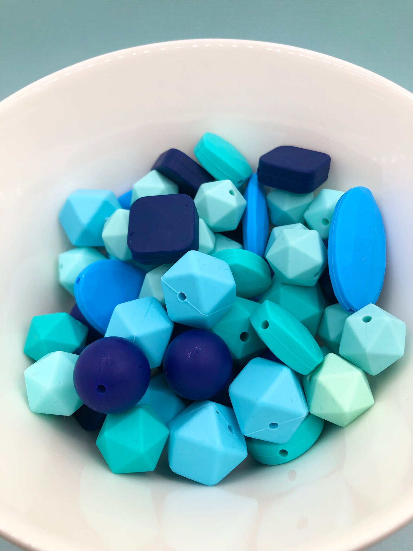 Variety pack of mixed size and shape silicone beads in various blue hues.