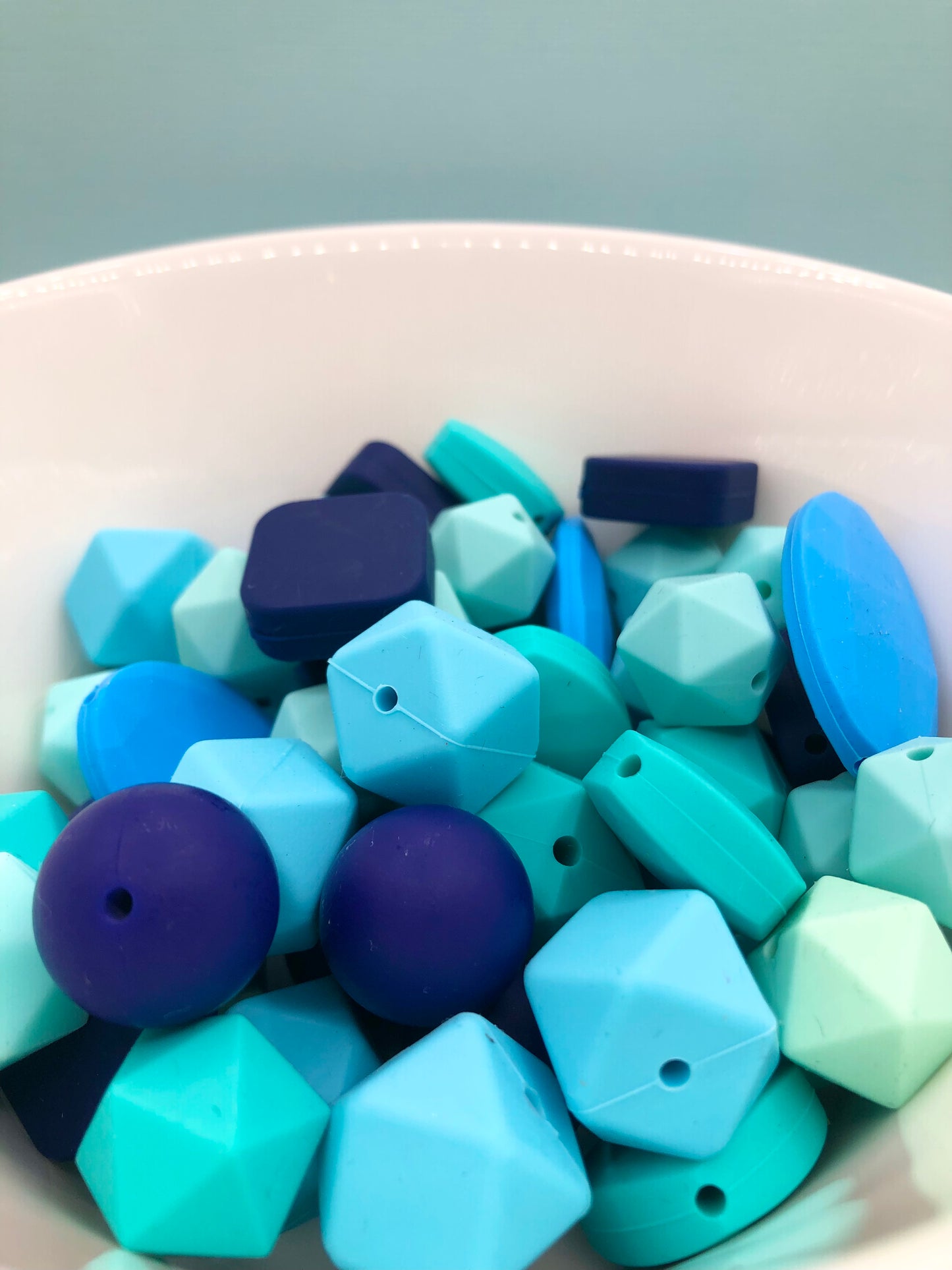 Variety pack of mixed size and shape silicone beads in various blue hues.