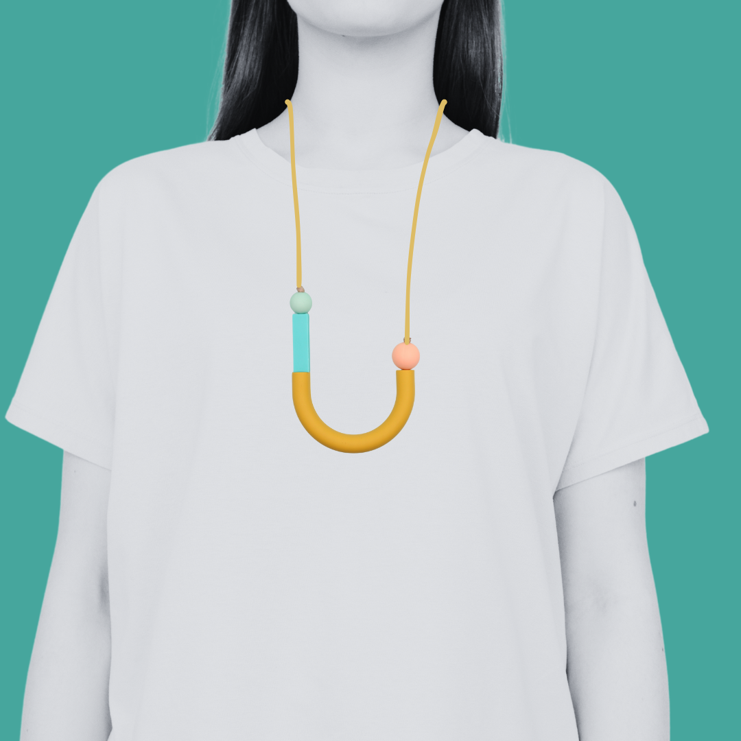 Model in white t shirt wearing a mixed bead silicone sensory necklace for ADHD and autistic adults to fiddle or chew.