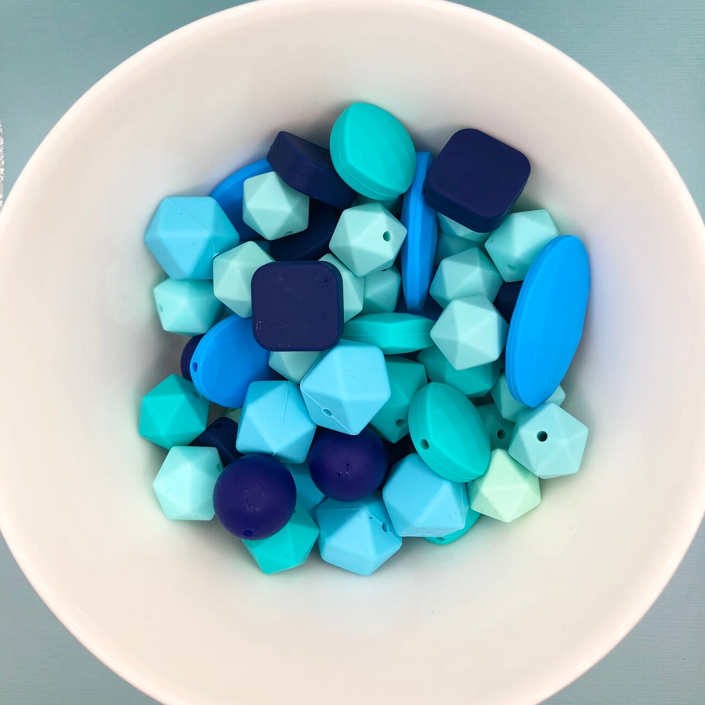 Variety pack of mixed size and shape silicone beads in various blue hues.