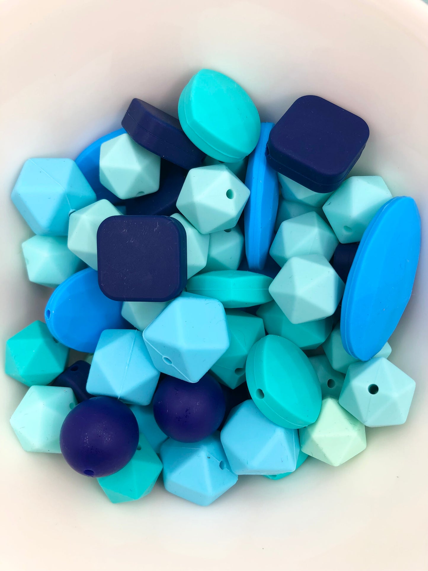 Variety pack of mixed size and shape silicone beads in various blue hues.