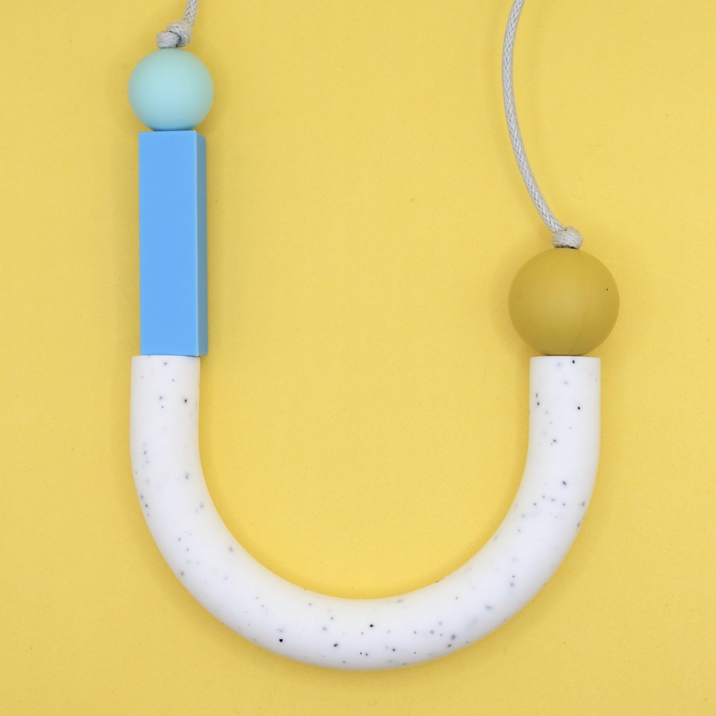 U-shaped silicone necklace for sensory and teething use worn by adults.