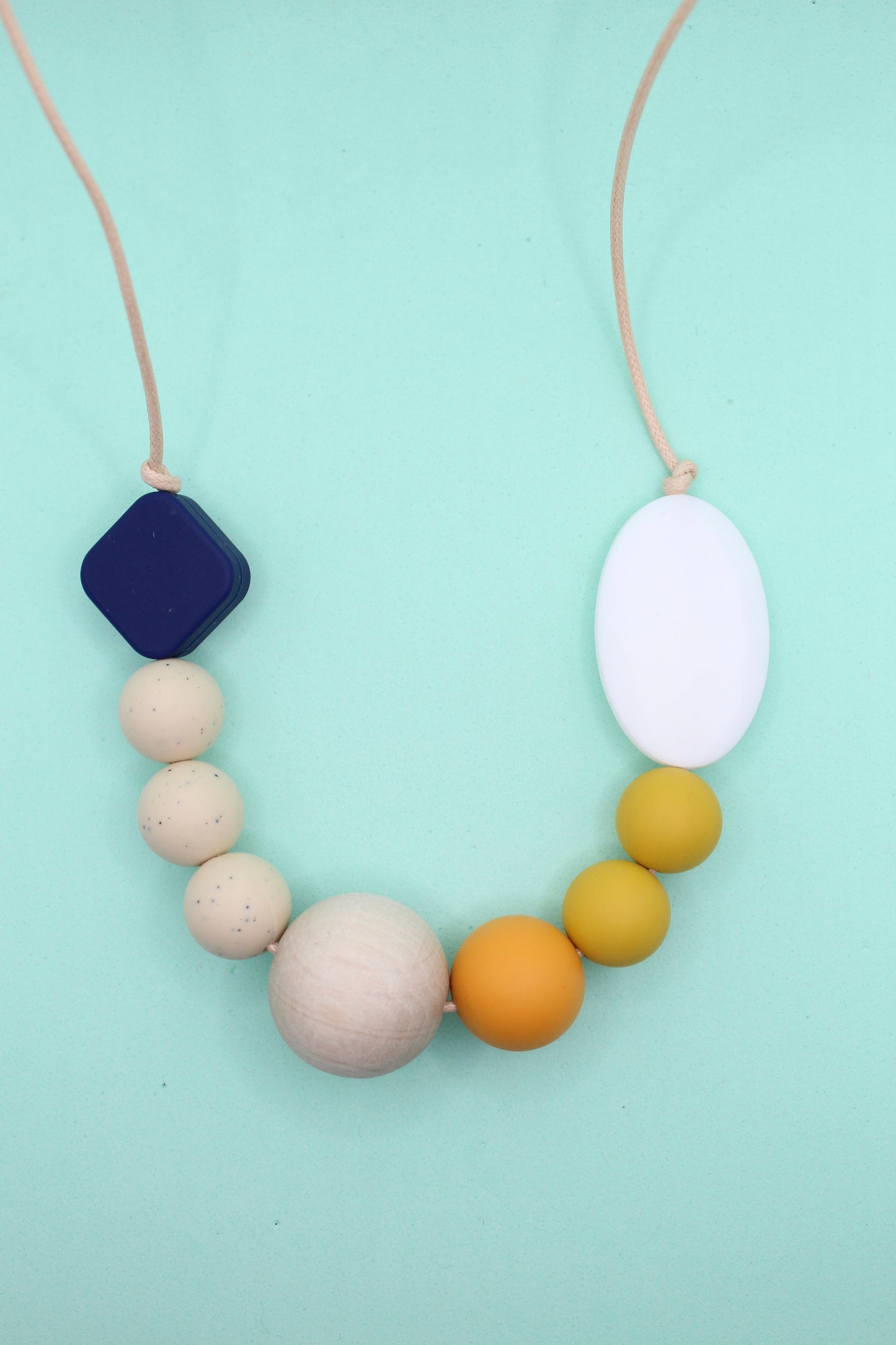 Navy and mustard silicone sensory necklace for adults featuring cream, mustard, and navy beads, with natural untreated wood elements. Autism-friendly and chewable.