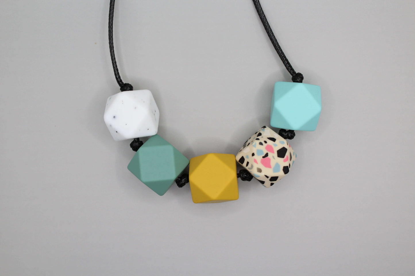 Hexagon silicone necklace with five beads in different colors on black cord, customizable sensory necklace suitable for ADHD and Autistic adults